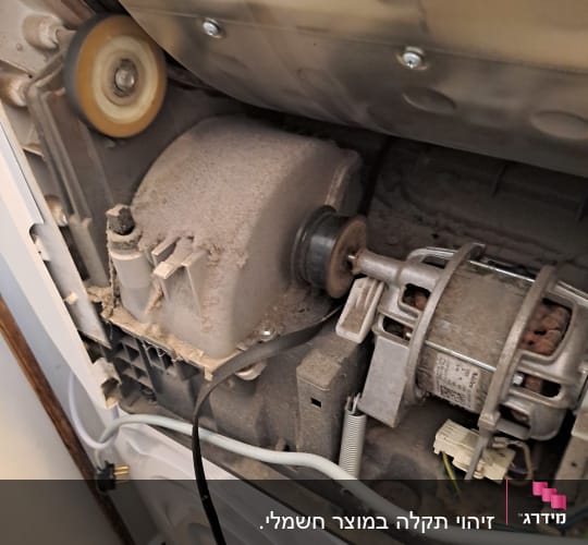 חלקים פנימיים של מכונת כביסה עם מנוע וחוטים חשמליים